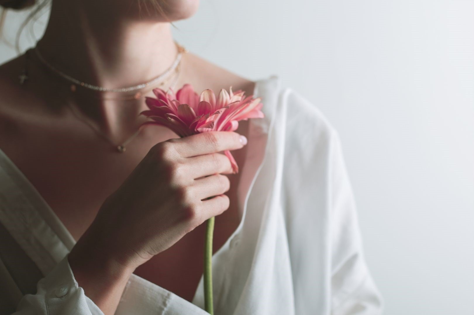 woman holding pink flower